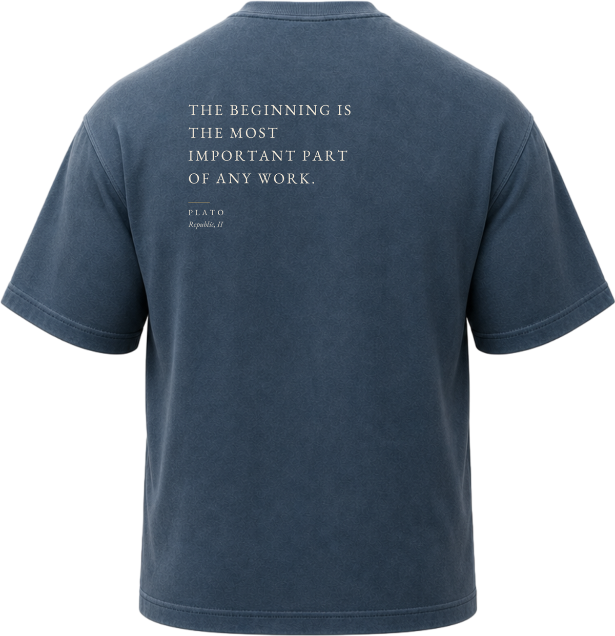 Pigment Midnight Navy
Back view of a faded, dark navy heavyweight cotton t-shirt cut in an intentionally oversized, boxy shape. The garment features architecturally balanced typography printed in Warm Parchment ink. The printed text reads: "THE BEGINNING IS THE MOST IMPORTANT PART OF ANY WORK." with the attribution "PLATO" and "Republic, II" directly underneath in a classic serif font.
