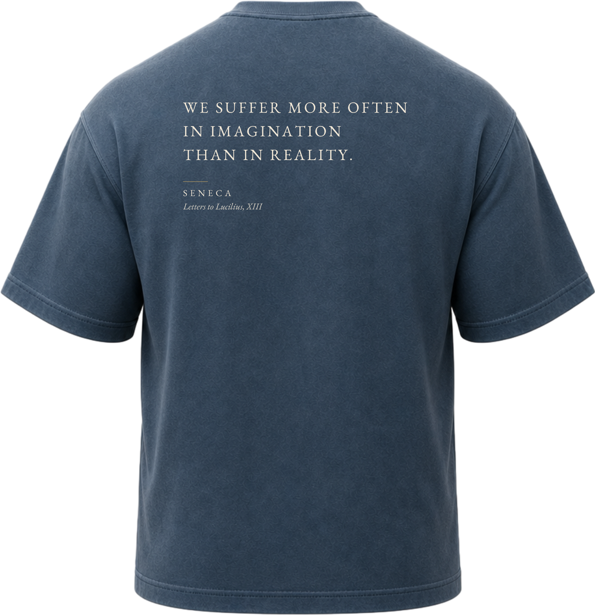 Pigment Midnight Navy
Back view of a faded, dark navy heavyweight cotton t-shirt cut in an intentionally oversized, boxy shape. The garment features architecturally balanced typography printed in Warm Parchment ink. The printed text reads: "WE SUFFER MORE OFTEN IN IMAGINATION THAN IN REALITY." with the attribution "SENECA" and "Letters to Lucilius, XIII" directly underneath in a classic serif font.