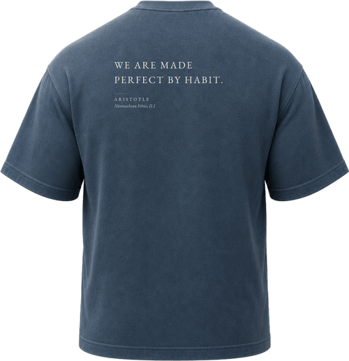 Pigment Midnight Navy
Back view of a faded, dark navy heavyweight cotton t-shirt cut in an intentionally oversized, boxy shape. The garment features architecturally balanced typography printed in Warm Parchment ink. The printed text reads: "WE ARE MADE PERFECT BY HABIT." with the attribution "ARISTOTLE" and "Nicomachean Ethics, II.1" directly underneath in a classic serif font.